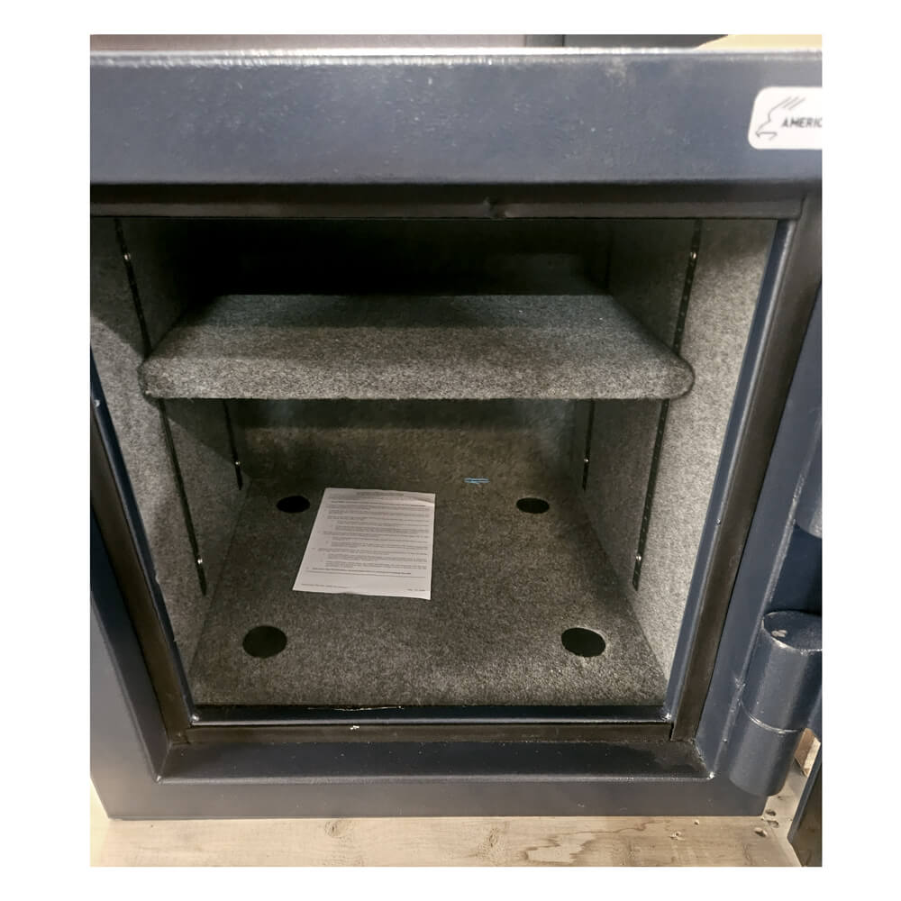 Open safe with interior view showing a piece of paper on a gray mat.
